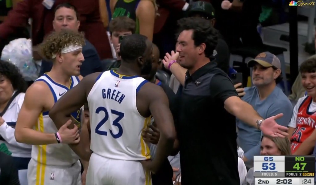 Draymond Green (23) de los Warriors aborda al fan de los Pelicans Sam Green (R.) durante el segundo cuarto el 16 de noviembre de 2025 en Nueva Orleans.
