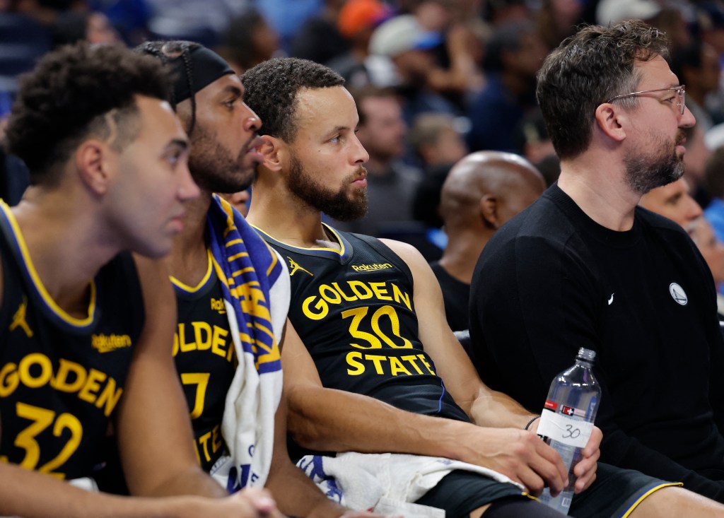El guardia de Golden State Warriors, Stephen Curry (30), observa a su equipo jugar desde el banco.