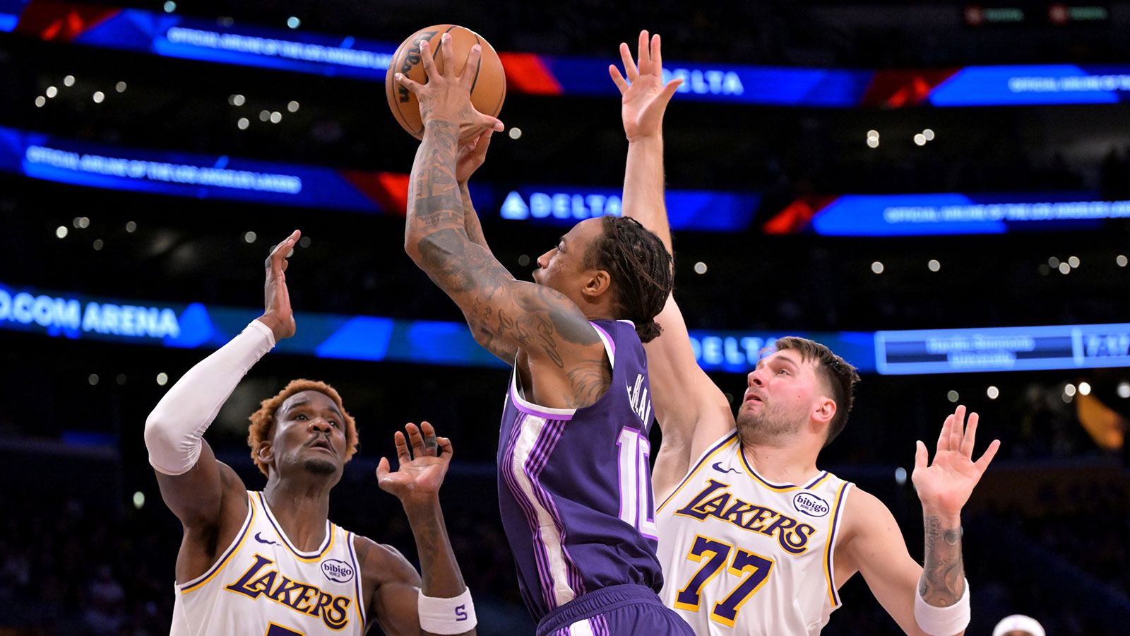 El guardia de los Angeles Lakers Luka Doncic (77) y el centro Deandre Ayton (5) defienden un tiro del guardia de los Sacramento Kings Demar Deroza (10) durante la primera mitad en Crypto.com Arena.