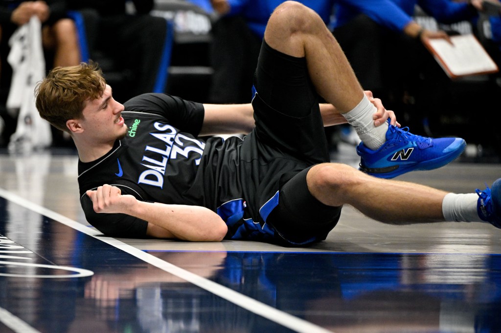 El delantero de los Dallas Mavericks, Cooper Flagg (32), se agarra el tobillo mientras baja durante el segundo cuarto contra los Denver Nuggets en el American Airlines Center.