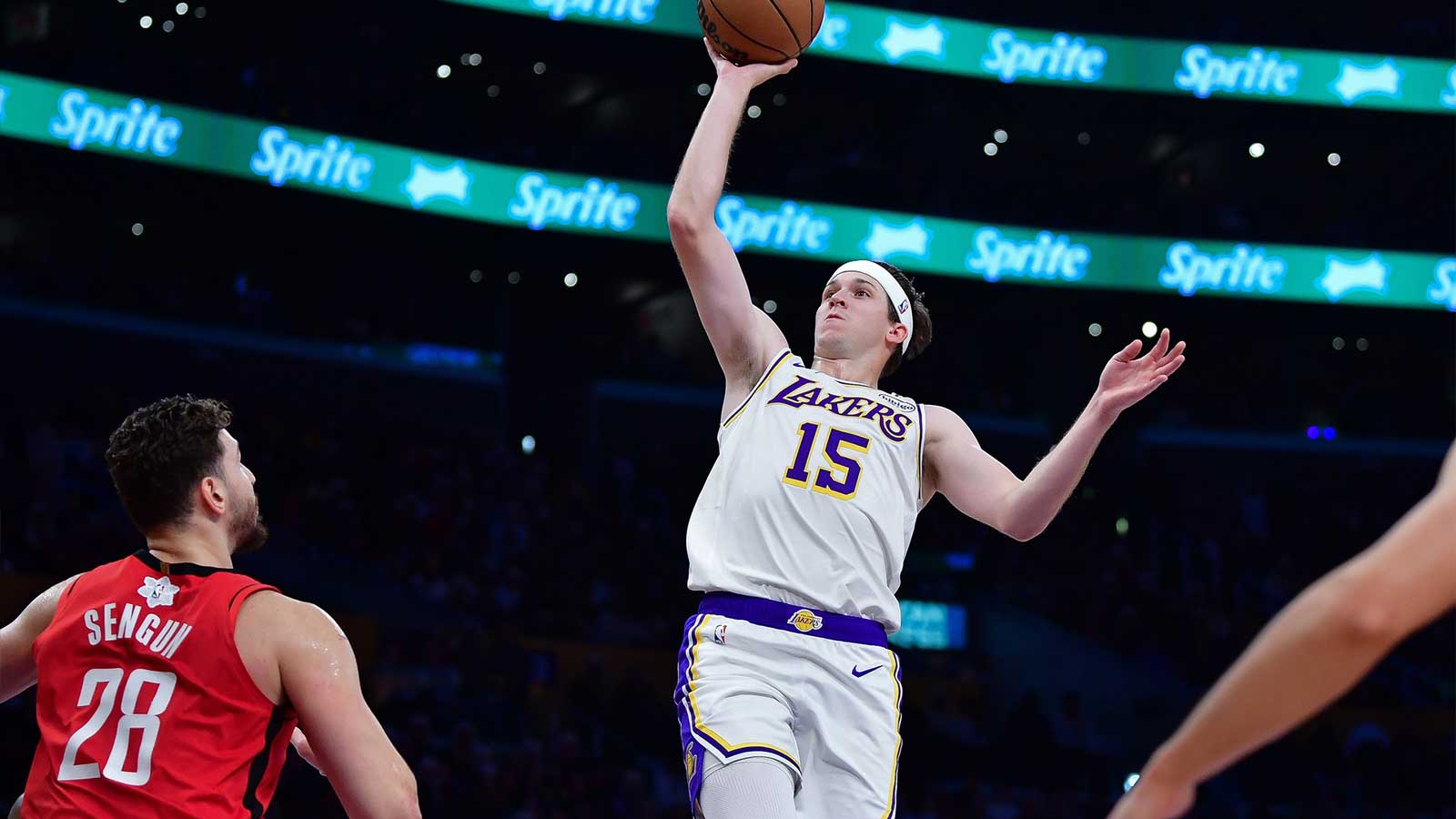 El guardia de los Lakers Austin Reaves (15) conduce hasta el centro de Houston Rockets Alperen Sengun (28) durante la primera mitad en Crypto.com Arena.