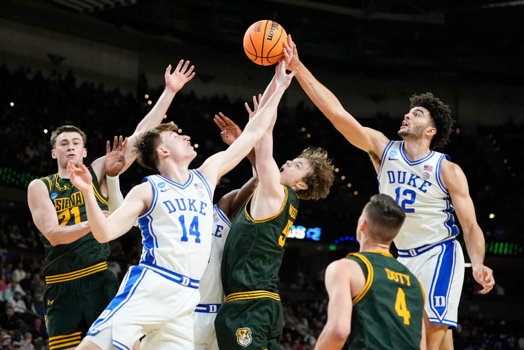 El delantero de Duke Cameron Boozer (12) intenta enfrentarse a Siena en la cancha de baloncesto