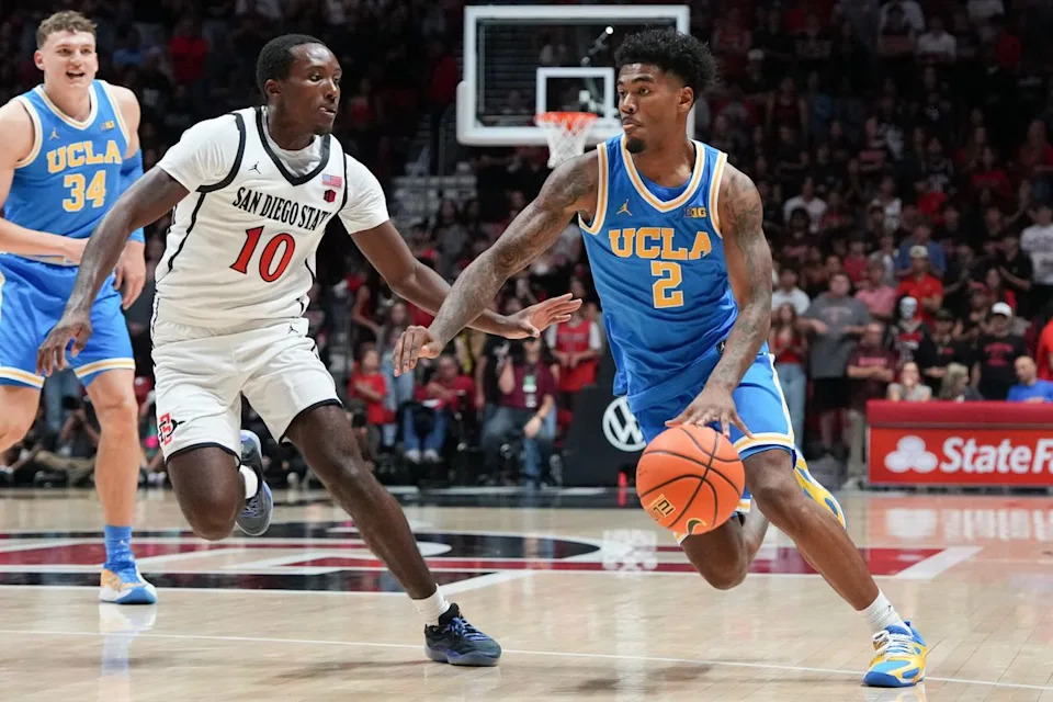 El guardia de UCLA, Donovan Dent (2), pasa junto a los defensores durante un partido de baloncesto de la NCAA contra SDSU el 17 de octubre de 2025 en San Diego, California.