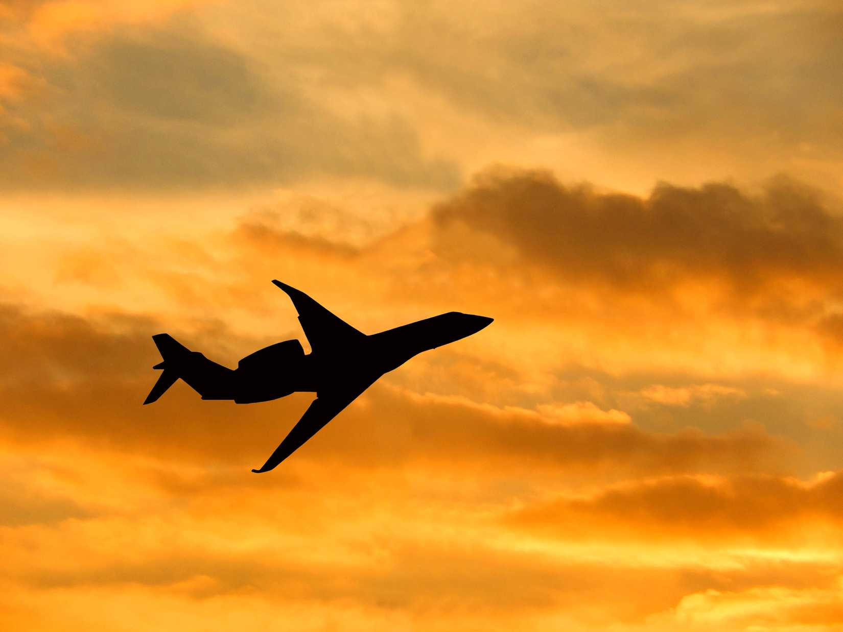 Silueta de un avión privado volando al atardecer