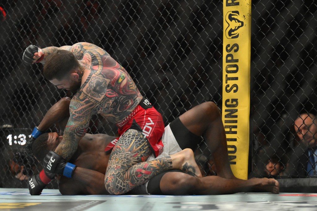 Sean Brady (guantes rojos) pelea contra Joaquin Buckley (guantes azules) en el suelo durante UFC 328.